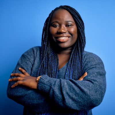 African american plus size woman with braids wearing casual sweater over blue background happy face smiling with crossed arms looking at the camera. Positive person.